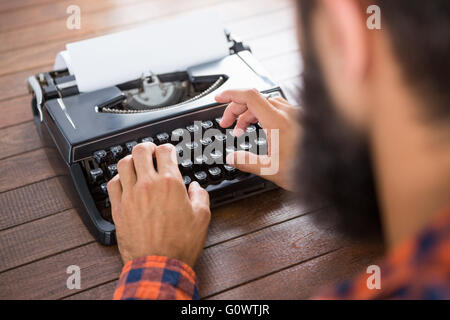 A man is typing on a type writer Stock Photo