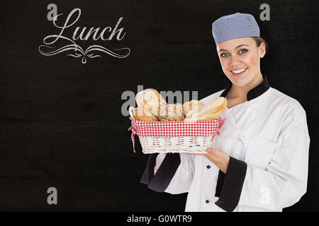 Composite image of woman in chef uniform with bread basket Stock Photo