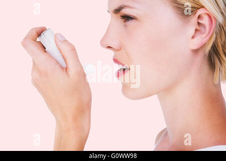 Composite image of asthmatic pretty blonde woman using inhaler Stock ...