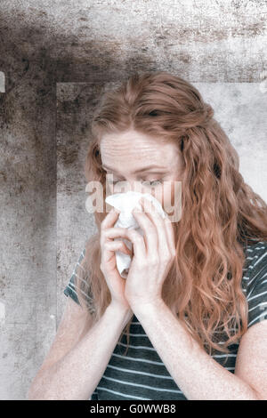 Composite image of sick blonde woman blowing her nose Stock Photo