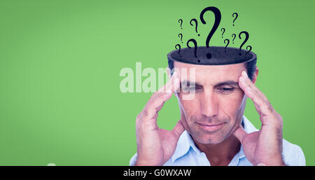 Composite image of handsome man thinking with hand on forehead Stock Photo