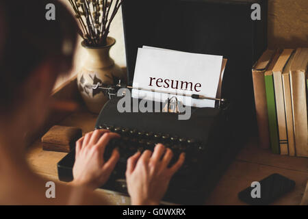 Resume against young woman using typewriter Stock Photo