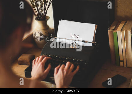 Blog against young woman using typewriter Stock Photo