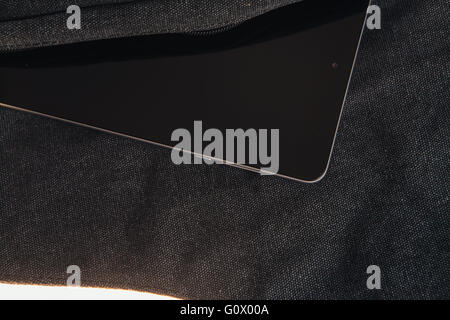 Tablet computer is on the dark bag on a  white background Stock Photo