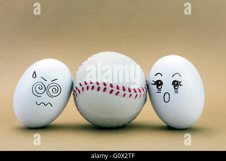 two eggs look missed at a baseball ball, conceptual image Stock Photo