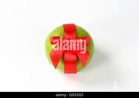 green grapefruit with red ribbon on white background Stock Photo