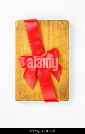 wooden cutting board with red ribbon and bow on white background Stock Photo