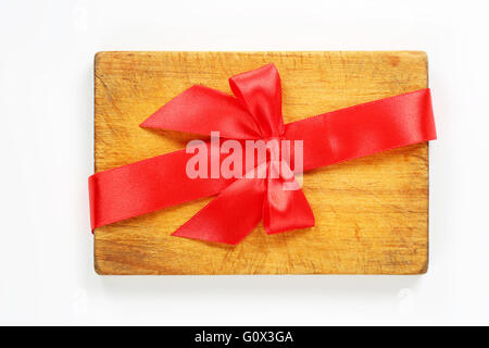 wooden cutting board with red ribbon and bow on white background Stock Photo