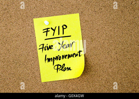 Business Acronym FYIP Five Year Improvement Plan written on yellow paper note pinned on cork board with white thumbtack, copy space available Stock Photo
