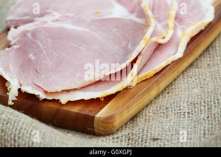 Ham slices wooden chopping board Stock Photo