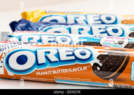 Food. Four packets of different flavoured Oreo biscuits next to each other. First one is peanut butter flavour. Plain white background. Stock Photo