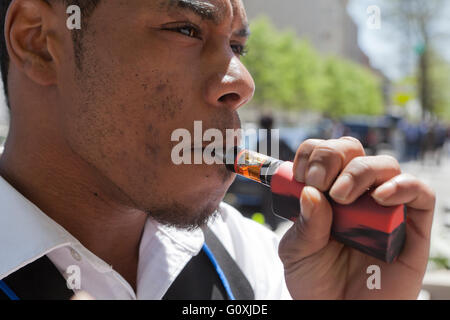 Young African-American man using an e-cigarette - USA Stock Photo
