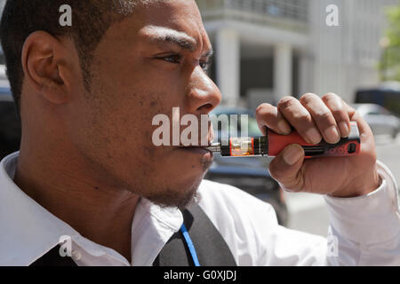 Young African-American man using an e-cigarette - USA Stock Photo