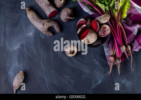 Sliced beetroot's in a bowl with beet leaves and cloth on blackboard Stock Photo