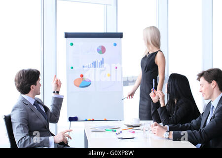 Workers at business meeting looking at presentation of financial reports in modern office Stock Photo