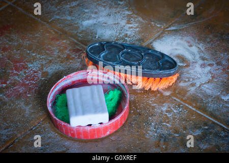 washing Soap and cleaning brush on the dirty floor. Stock Photo