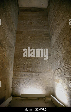 indoor room with stone walls of Egyptian Edfu Temple of falcon god Horus, with carving figures and hieroglyphs, in Egypt, Africa Stock Photo