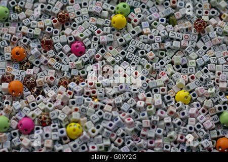English alphabets on beads spread for making ornaments. Stock Photo