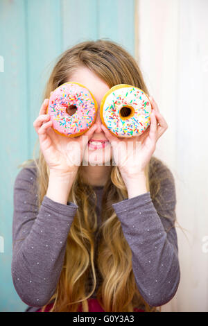 Girl looking through donuts Stock Photo
