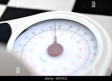 Bathroom scales on checkered floor Stock Photo