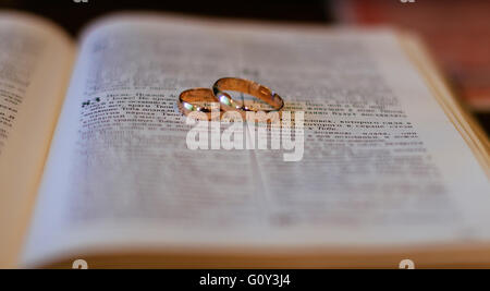 Two wedding rings on a bible Stock Photo