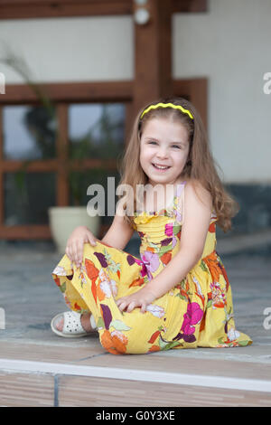 Portrait of a smiling girl sitting on terrace Stock Photo
