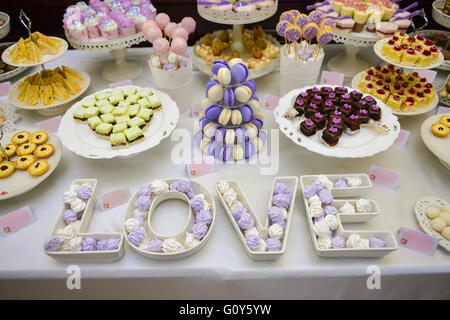 Love made with marshmallows white and mauve. A lot of candy on background. Stock Photo