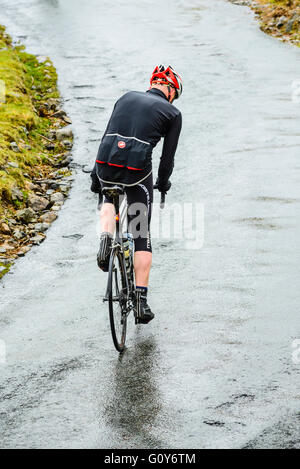 Rider ascending Hardknott Pass during the Fred Whitton Challenge, a 180km/112 mile sportive ride in the English Lake District Stock Photo