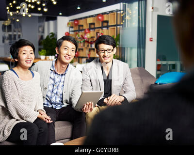 a team of young asian business people talking to boss and or investor Stock Photo