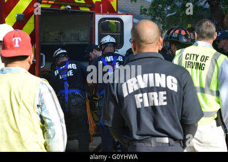 Irving, TX, USA. 5th May, 2016. Rescue workers watch as paramedics place injured  construction worker into an ambulance. Credit:  Brian Humek/Alamy Live News. Stock Photo