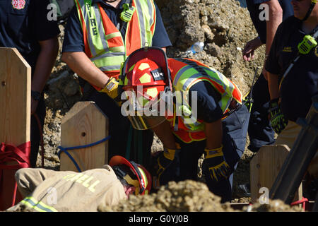 Irving, TX, USA. 5th May, 2016. Rescue workers help dig out a construction worker who was trapped in a twelve foot deep ditch. Credit:  Brian Humek/Alamy Live News. Stock Photo