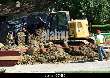 Irving, TX, USA 5th May, 2016. Friend watches on as resucers help extract a trapped construction who had fallen into a 12 ft. deep trench.  Credit:  Brian Humek/Alamy Live News. Stock Photo