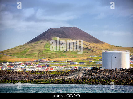 August 3, 2015 - Infamous Eldfell volcano, over 200 m (660 ft) high, overlooking Heimaey port on Heimaey Island, in the Westman Islands archipelago group (Vestmannaeyjar), scattered off the south coast of Iceland. In 1973, without warning, lava flow and volcanic ash, from its violent eruption destroyed half the town and threatened to close the harbor, its main income source. Dependent on its fishing industry, but noted for its seabird population, tourism and bird watching are a growing sector of the economy of Heimaey as Iceland becomes a favorite tourist destination. (Credit Image: © Arnold D Stock Photo