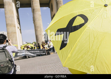 Berlin, Berlin, Germany. 6th May, 2016. Protesters hold yellow umbrellas with a black ribbons in front of Brandenburg Gate to commemorate the victims during the rally of Sewol Families in Berlin. The parents of the Sewol victims and campaigners demand justice for the victims and proper safety laws and regulations. The Sewol ferry capsized and sank with the loss of 304 passengers, mostly high school children, and crew on April 16, 2014. Credit:  Jan Scheunert/ZUMA Wire/Alamy Live News Stock Photo