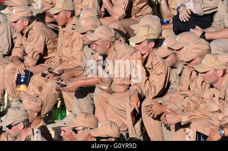 Russian soldiers listen to the St Petersburg Mariinsky Theater symphony orchestra performing at the Roman amphitheater ruins May 5, 2016 in Palmyra, Syria. The performance follows the liberation of the historic heritage site after months of fighting by Russian and Syrian forces fighting the Islamic State. Stock Photo