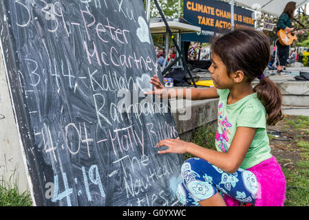 Young  girl drawing heart on chalkboard. Stock Photo