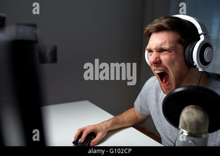 man in headset playing computer video game at home Stock Photo