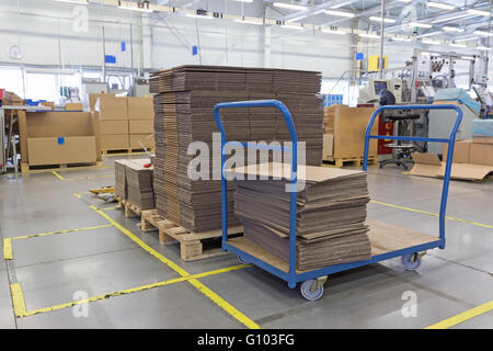 Cardboard boxes are folded in a designated place in the assembly hall. The show of lean management. Stock Photo