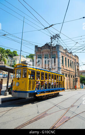 RIO DE JANEIRO - MARCH 28, 2016: Tourists ride the new version of the iconic bonde tram in the heart of Santa Teresa. Stock Photo