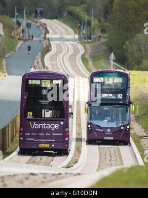 Two double decker buses passing on new concrete guided busway Stock Photo