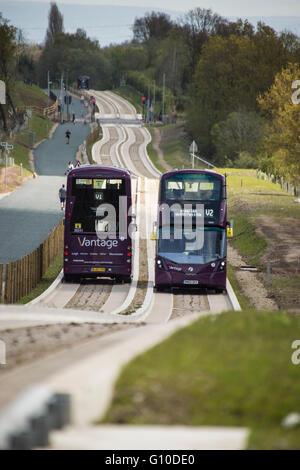 Two double decker buses passing on new concrete guided busway Stock Photo