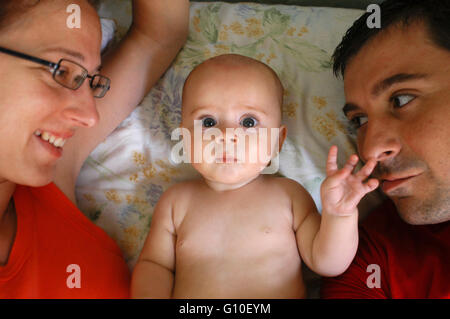 Caucasian family smiling on bed Stock Photo