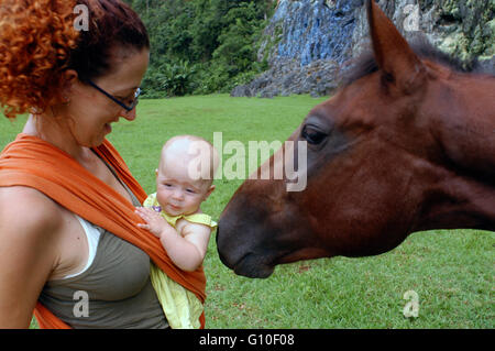 Mother with her baby and a horse in The Prehistory mural, Pinar del Rio, Cuba. Painted in the wall of a cliff is one of the popular attractions in the landmark Stock Photo