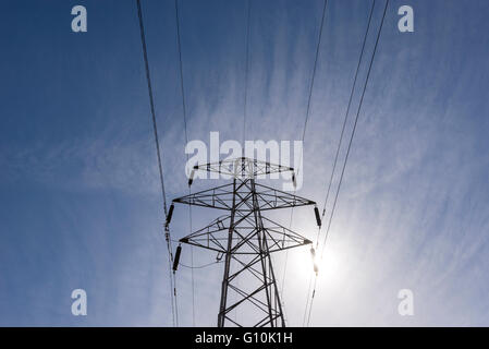 Looking up into the frame of an electricity pylon with clear blue sky overhead. Stock Photo