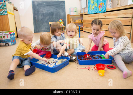 Children improving motor skills of hands with rice and beans Stock Photo