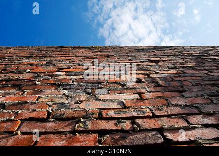 Old brick wall with blue sky above Stock Photo