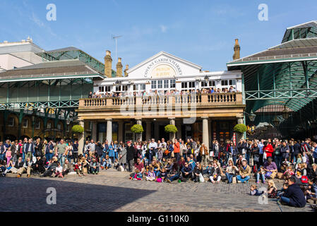 Tourists watching a busker show in the square in front of Covent Garden Market Stock Photo