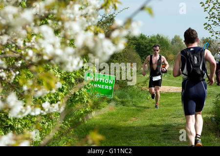 Stratford-upon-Avon, Warwickshire, UK. 8th May, 2016. Competitors pass spring blossom in the running stage of the Stratford Triathlon. Credit:  Colin Underhill/Alamy Live News Stock Photo
