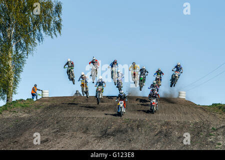 large group of riders on motorcycles jumping over a mountain during Cup of Urals motocross Stock Photo