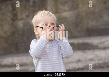 Happy child with falling down glasses, outdoors Stock Photo